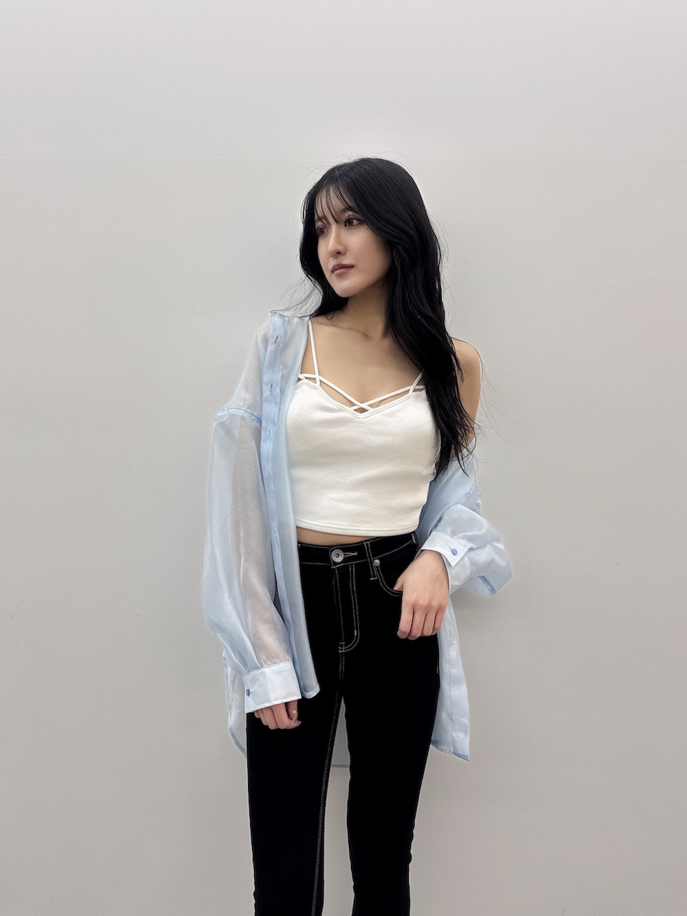 ブルー系のシャツ/ブラウス、ホワイト系のキャミソール、ブラック系のデニムパンツを着用したレディースの春コーディネートの3枚目の写真