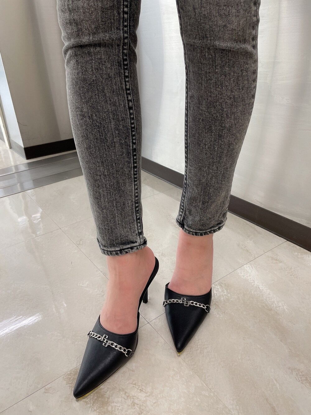 ブラック系のデニムパンツ、ブラック系のニット/セーター、ブラック系のパンプスを着用したレディースの秋コーディネートの9枚目の写真