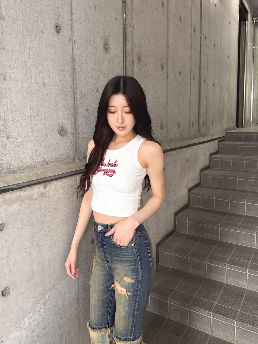 ホワイト系のタンクトップ、ブルー系のデニムパンツ、ホワイト系のサンダルを着用したレディースの春コーディネートの2枚目の写真