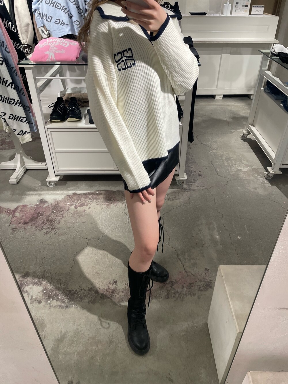 ホワイト系のニット/セーター、ブラック系のスカート、ブラック系のブーツを着用したレディースの冬コーディネートの5枚目の写真