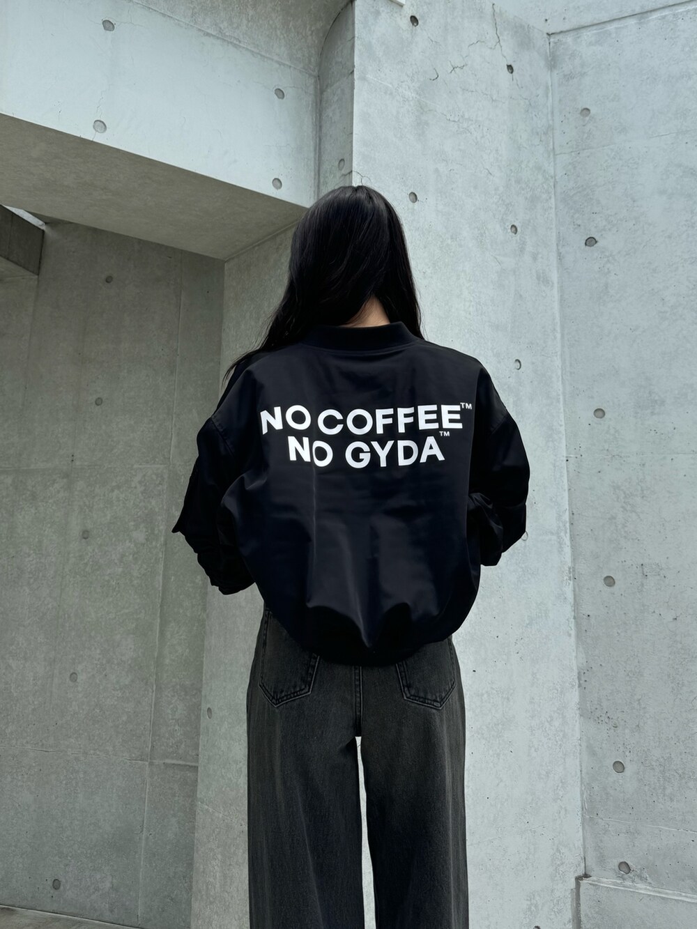 ブラック系のブルゾン、ブラック系のキャミソール、ブラック系のデニムパンツを着用したレディースの秋コーディネートの4枚目の写真