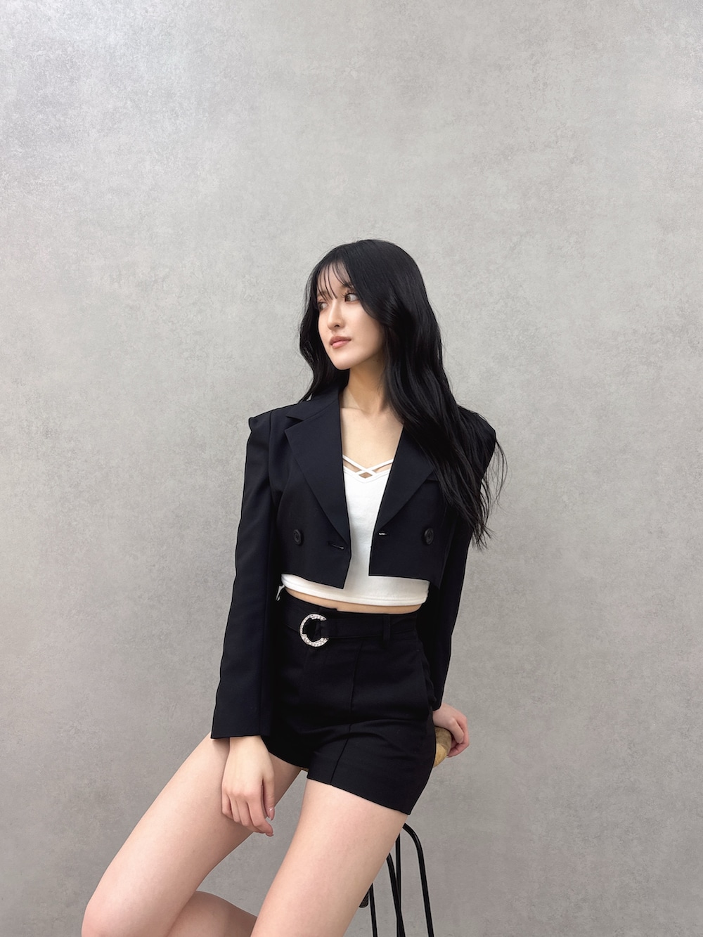 ブラック系のテーラードジャケット、ブラック系のその他パンツ、ホワイト系のキャミソールを着用したレディースの冬コーディネートの2枚目の写真