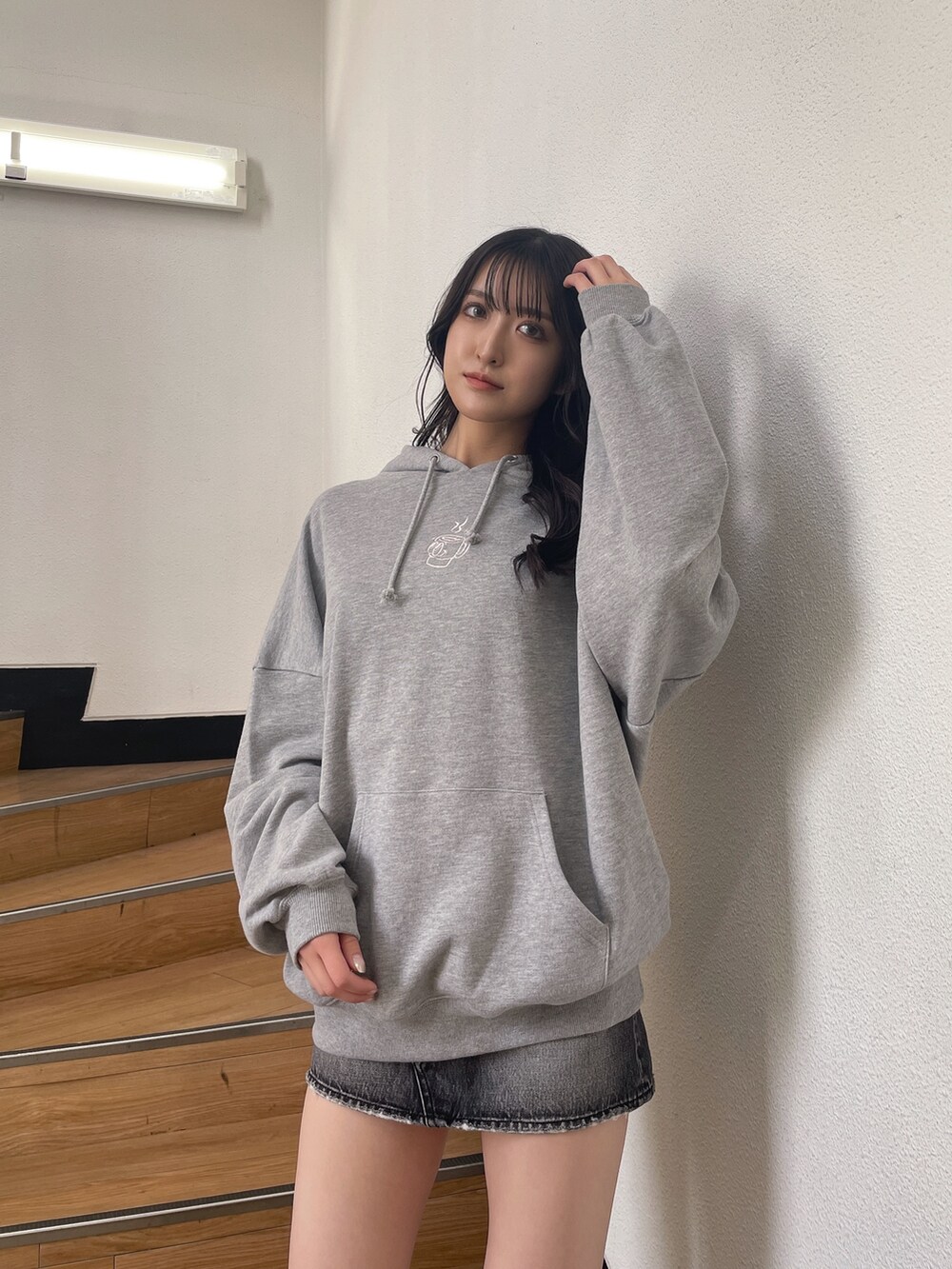 グレー系のスウェット、ブラック系のデニムスカート、ブラック系のブーツを着用したレディースの秋コーディネートの3枚目の写真