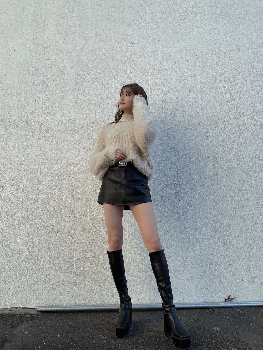 ホワイト系のニット/セーター、ブラック系のスカート、ブラック系のブーツを着用したレディースの冬コーディネートの3枚目の写真