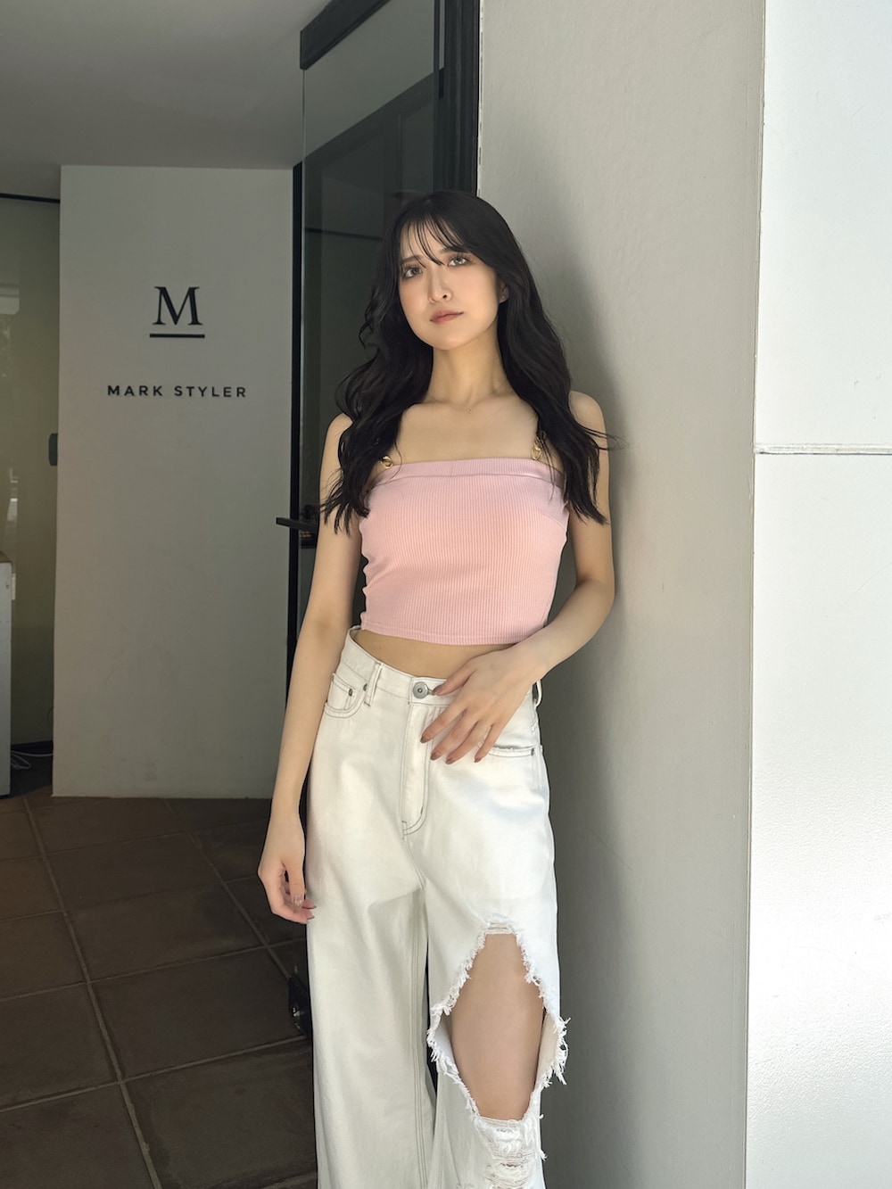 ピンク系のキャミソール、ホワイト系のデニムパンツ、ホワイト系のパンプスを着用したレディースの夏コーディネートの2枚目の写真