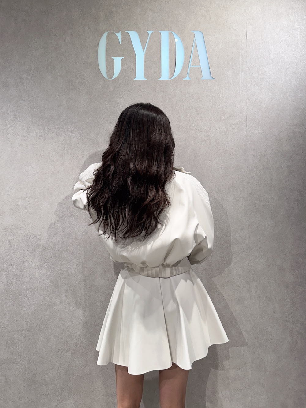 ホワイト系のブルゾン、ホワイト系のニット/セーター、ホワイト系のスカートを着用したレディースの冬コーディネートの4枚目の写真