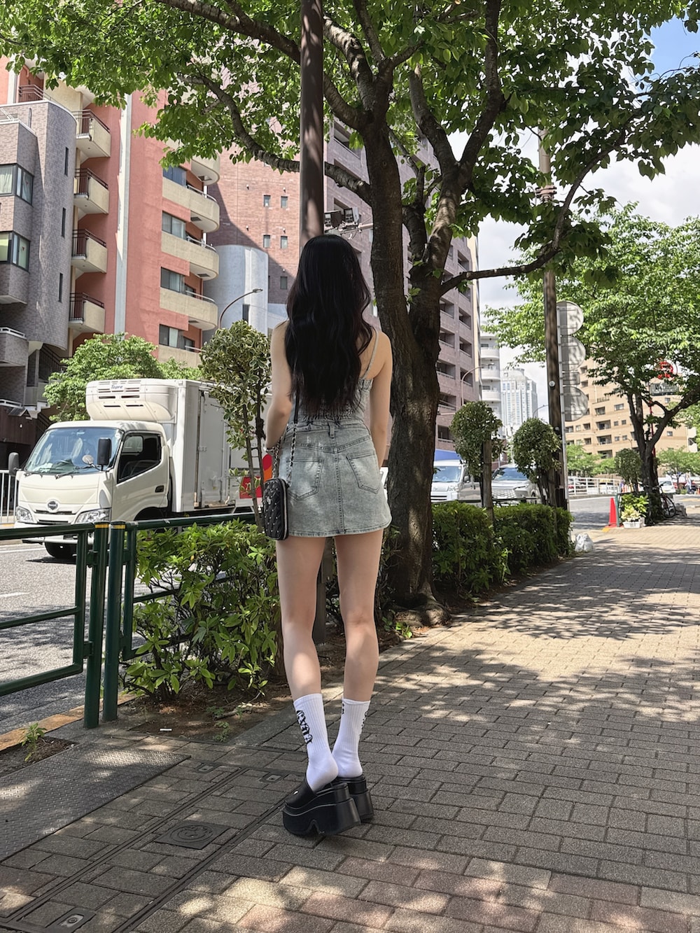 ブルー系のワンピース、ブラック系のショルダーバッグ、ホワイト系のソックス/靴下を着用したレディースの春コーディネートの2枚目の写真