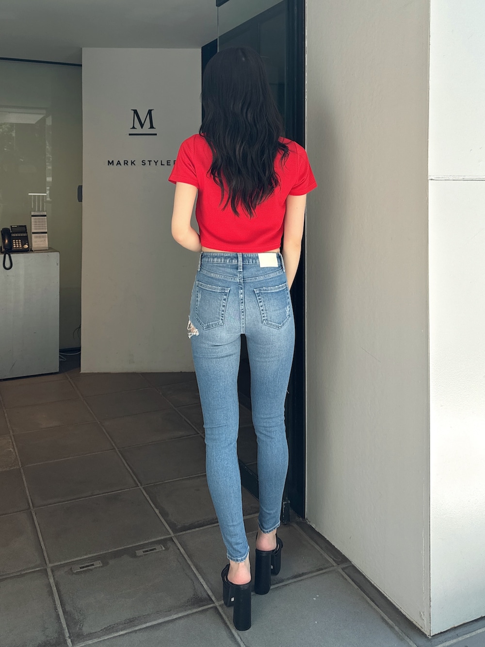 レッド系のTシャツ/カットソー、ブルー系のデニムパンツ、ブラック系のサンダルを着用したレディースの夏コーディネートの4枚目の写真