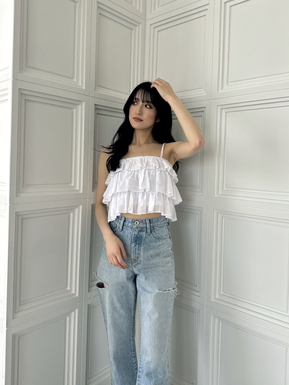 ホワイト系のキャミソール、ブルー系のデニムパンツ、ホワイト系のサンダルを着用したレディースの夏コーディネートの3枚目の写真