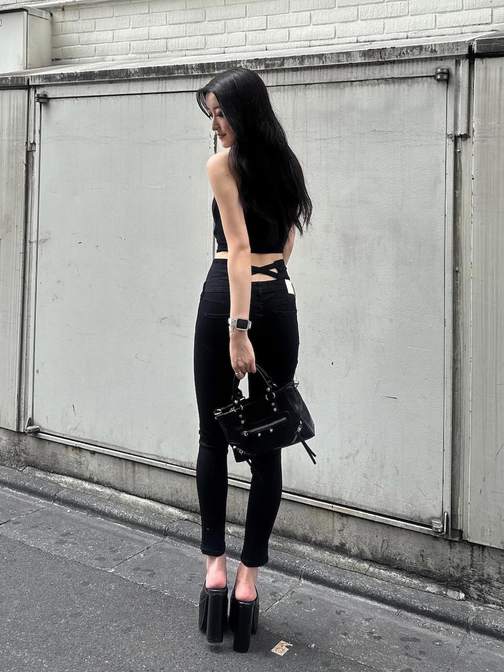 ブラック系のデニムパンツ、ブラック系のキャミソール、ブラック系のサンダルを着用したレディースの夏コーディネートの4枚目の写真