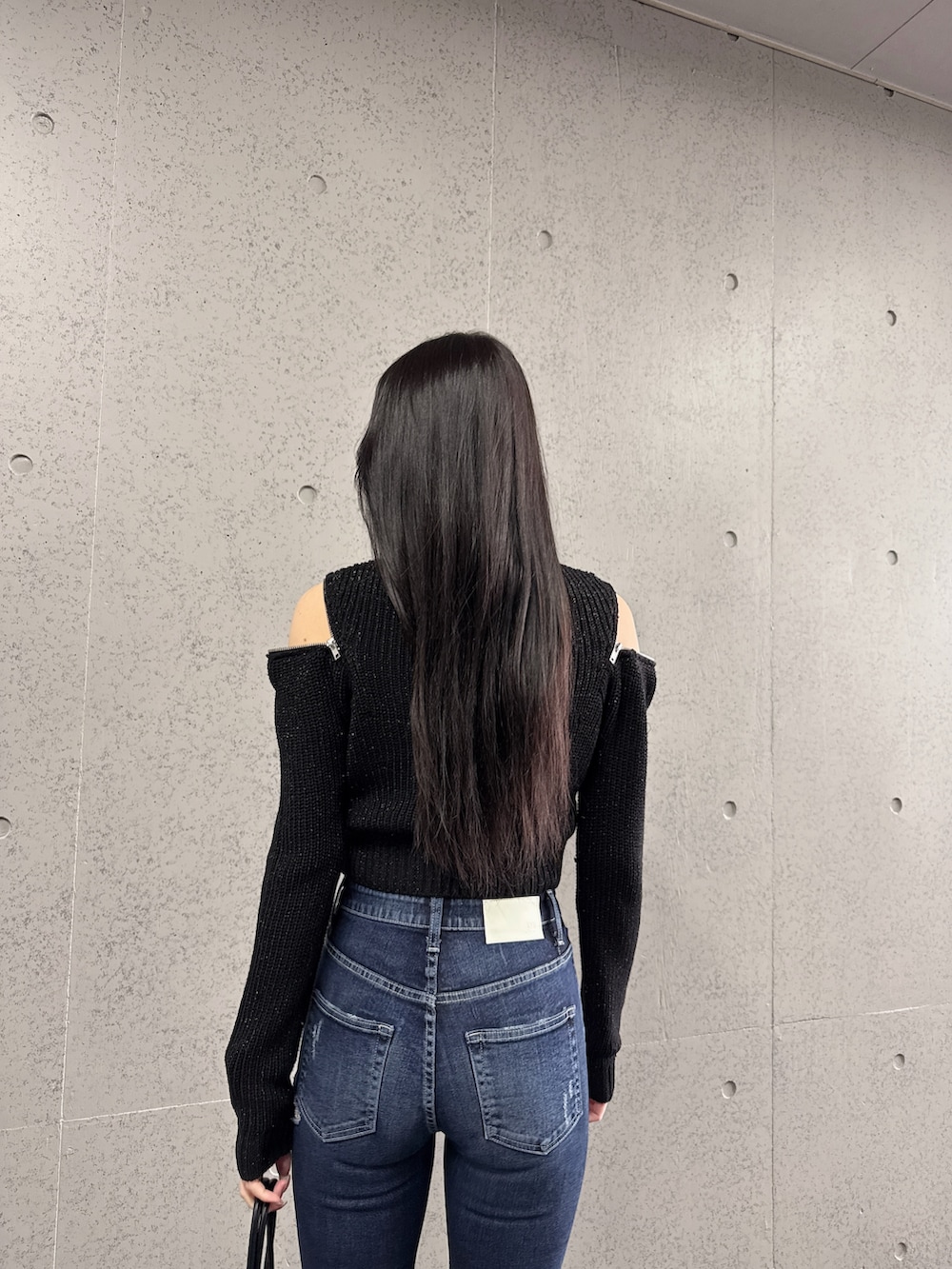 ブラック系のニット/セーター、ブラック系のブーツを着用したレディースの冬コーディネートの3枚目の写真