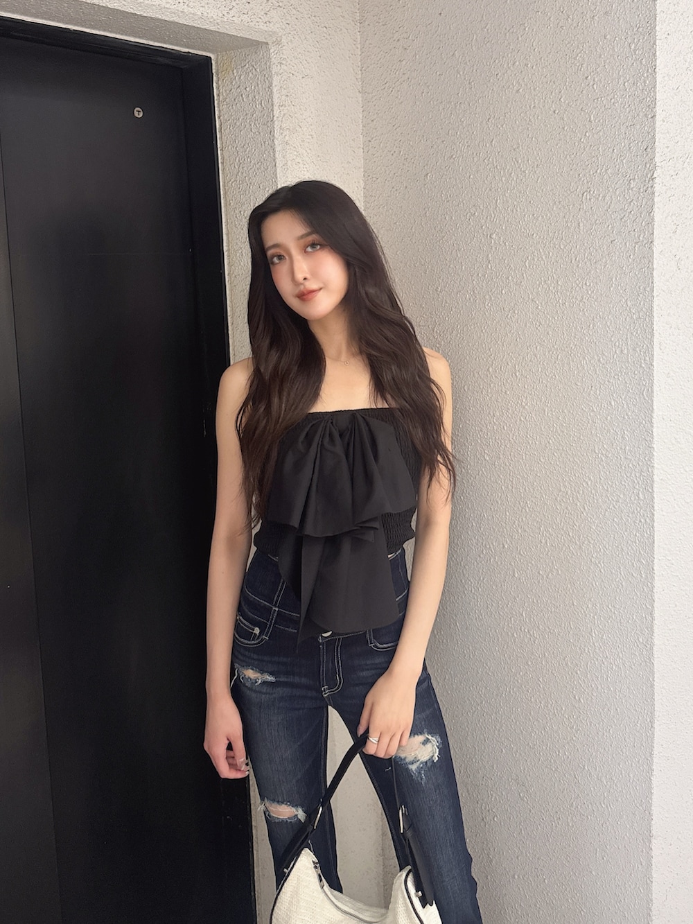 ブラック系のシャツ/ブラウス、ブルー系のデニムパンツ、ホワイト系のハンドバッグを着用したレディースの夏コーディネートの3枚目の写真