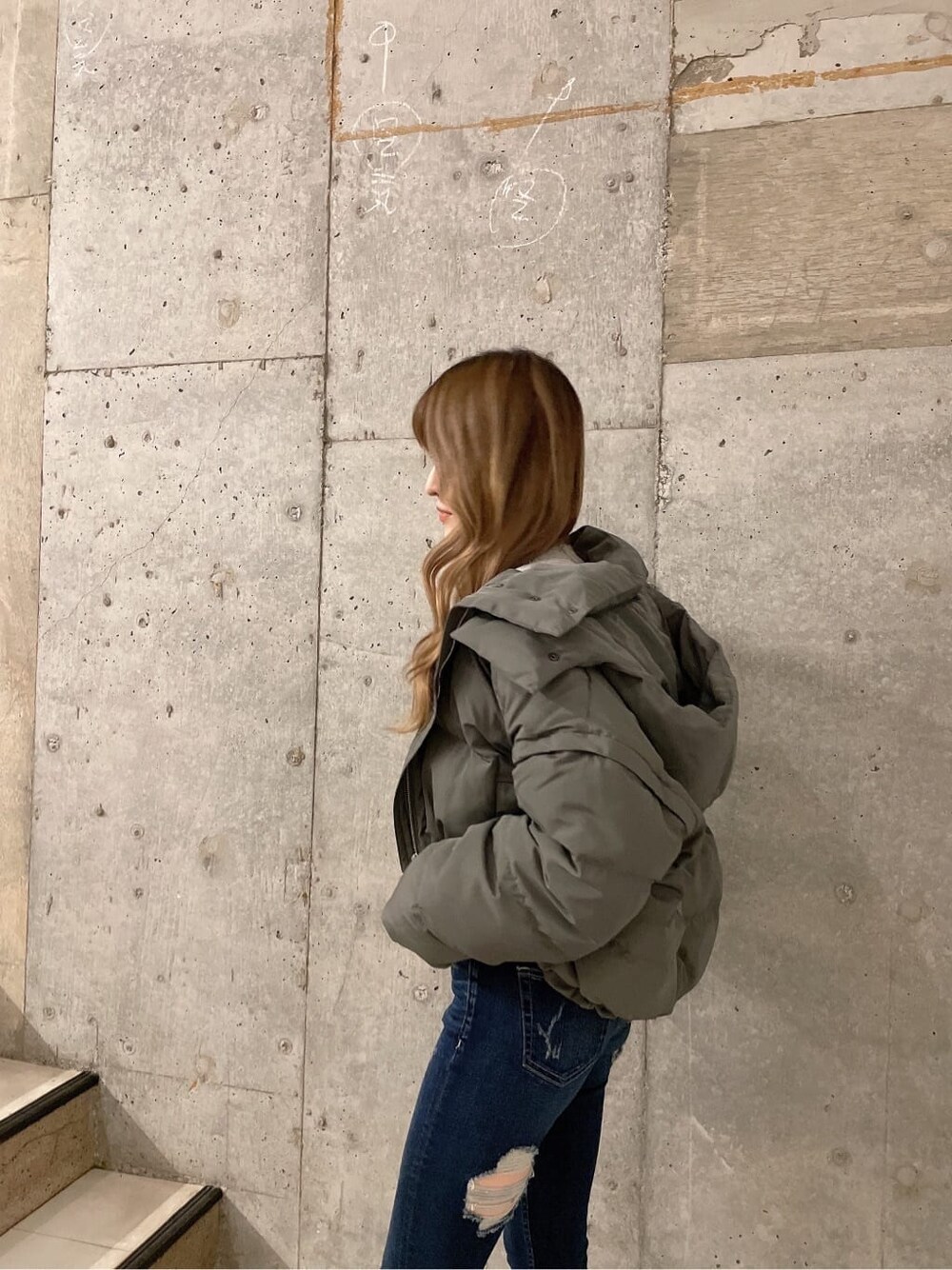 ベージュ系のダウンジャケット/コート、ブラック系のブーツ、グレー系のスウェットを着用したレディースの秋コーディネートの3枚目の写真