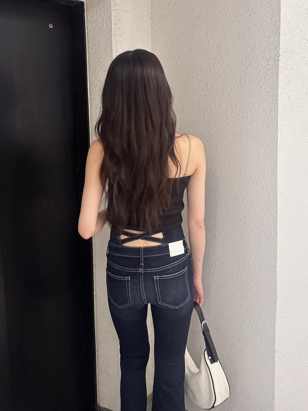 ブラック系のシャツ/ブラウス、ブルー系のデニムパンツ、ホワイト系のハンドバッグを着用したレディースの夏コーディネートの4枚目の写真