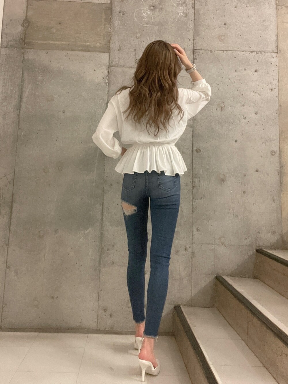 ブルー系のデニムパンツ、ホワイト系のシャツ/ブラウス、ホワイト系のパンプスを着用したレディースの冬コーディネートの5枚目の写真