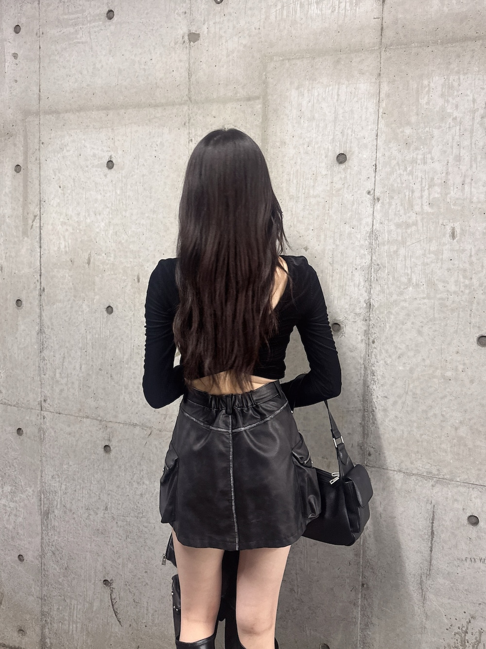 ブラック系のスカート、ブラック系のブーツ、ブラック系のブルゾンを着用したレディースの秋コーディネートの5枚目の写真