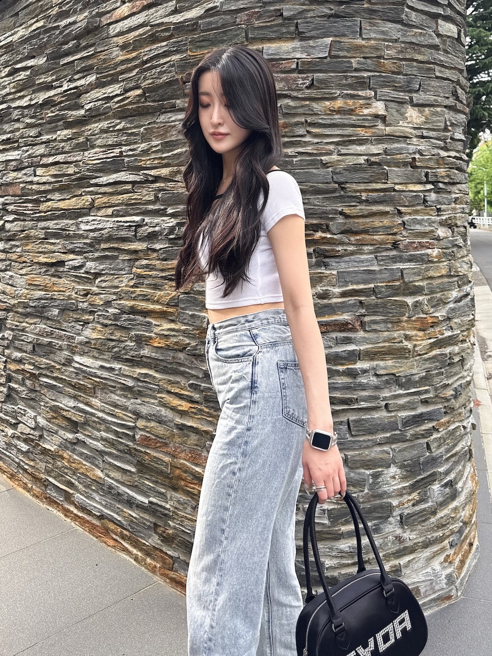 ホワイト系のTシャツ/カットソー、ブラック系のボストンバッグ、ブルー系のデニムパンツを着用したレディースの夏コーディネートの5枚目の写真