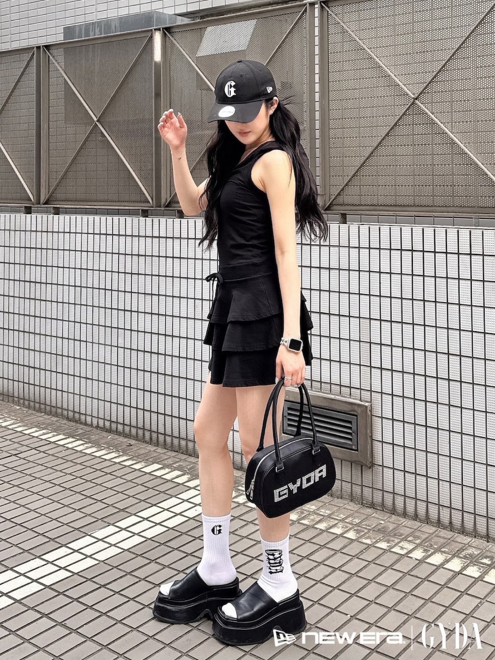 ブラック系のワンピース、ブラック系のボストンバッグ、ブラック系のキャップを着用したレディースの夏コーディネートの2枚目の写真