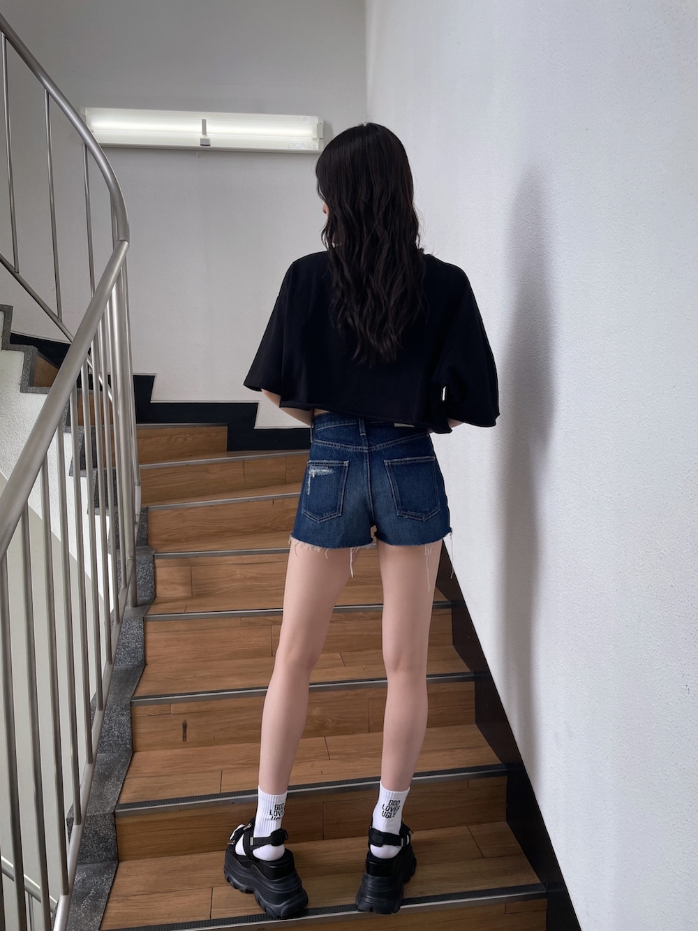 ブラック系のTシャツ/カットソー、ブルー系のデニムパンツ、ブラック系のサンダルを着用したレディースの春コーディネートの3枚目の写真