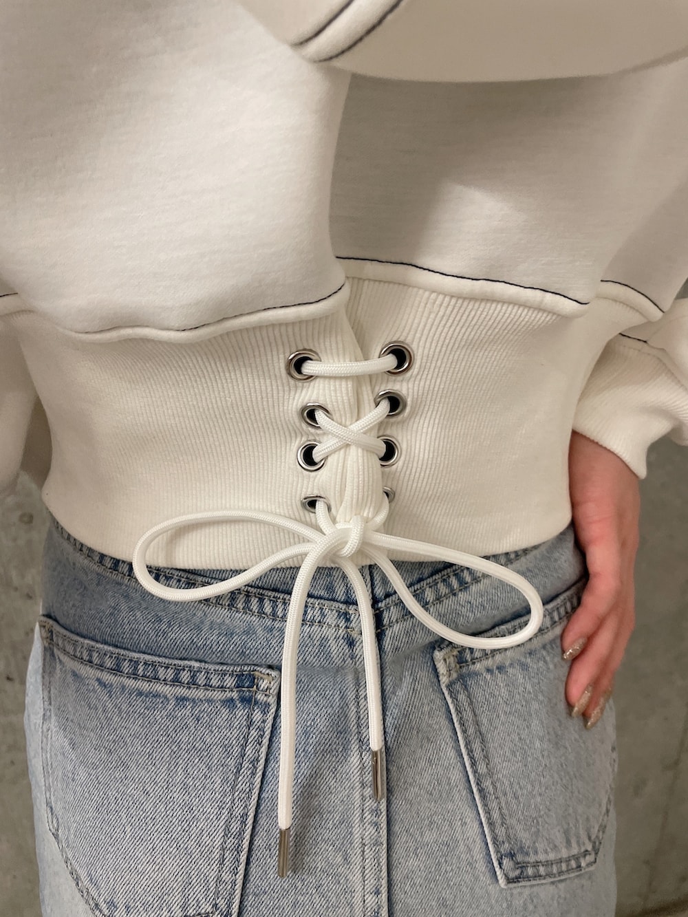 ホワイト系のパーカー、ブルー系のデニムスカート、ホワイト系のパンプスを着用したレディースの冬コーディネートの9枚目の写真