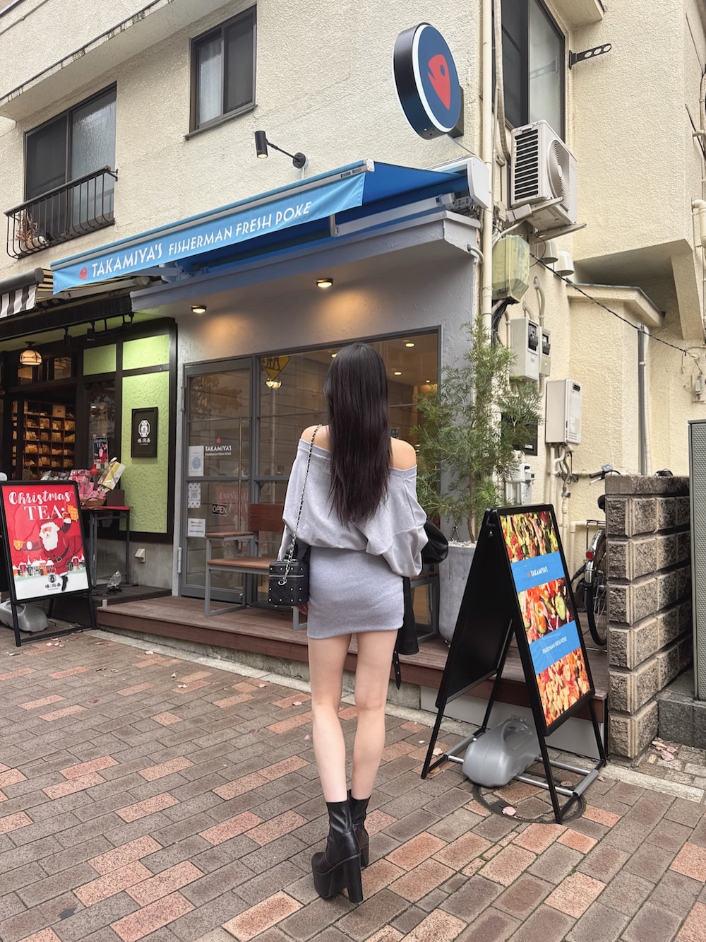 グレー系のワンピース、ブラック系のブーツを着用したレディースの冬コーディネートの3枚目の写真