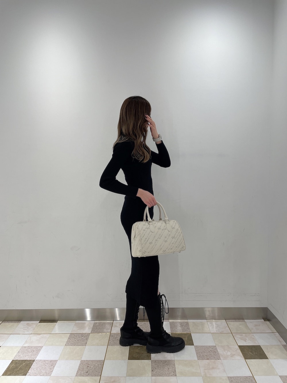 ブラック系のワンピース、ブラック系のブーツ、ホワイト系のボストンバッグを着用したレディースの秋コーディネートの4枚目の写真