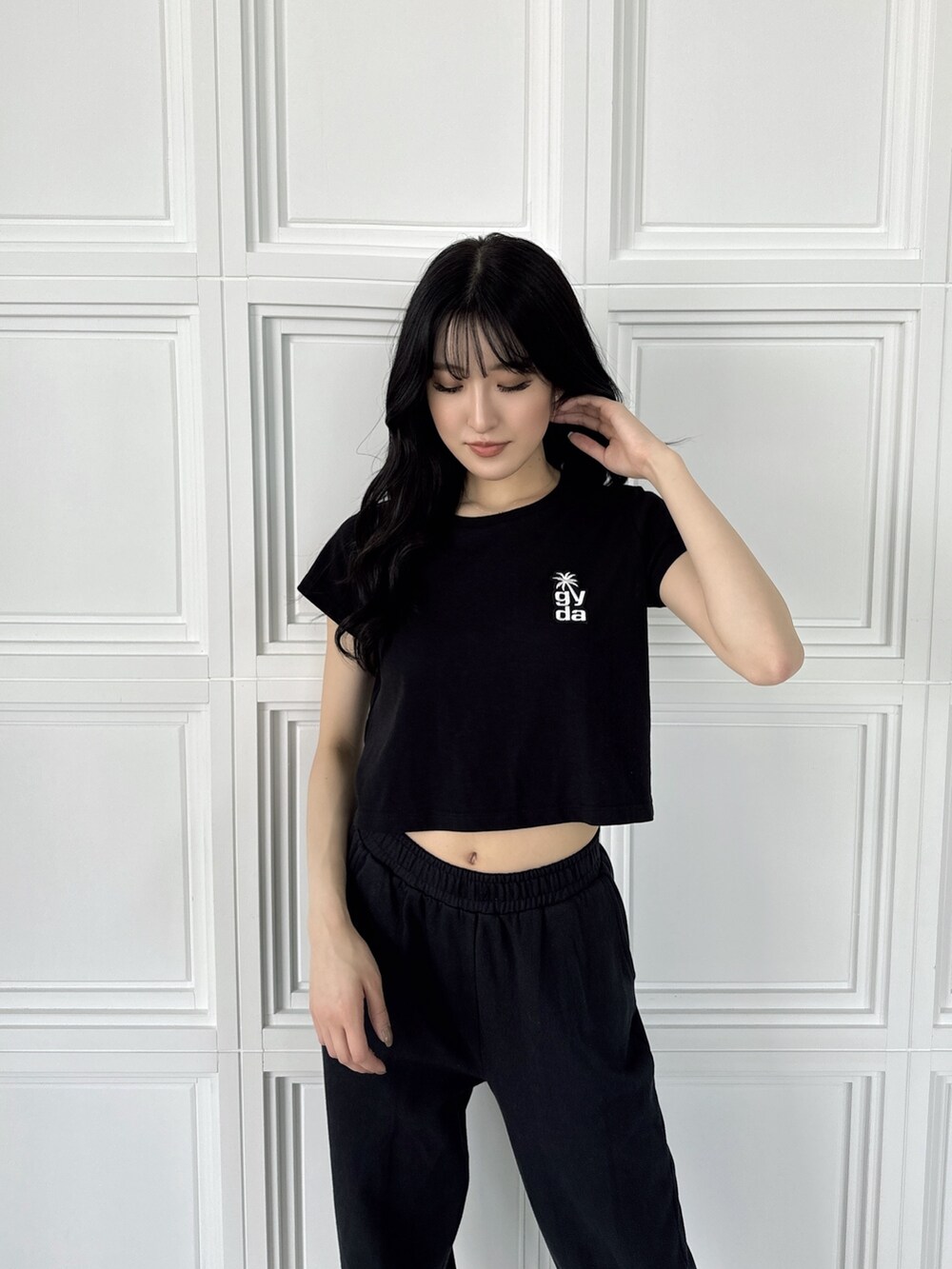 ブラック系のスウェットパンツ、ブラック系のTシャツ/カットソー、ホワイト系のパンプスを着用したレディースの夏コーディネートの3枚目の写真