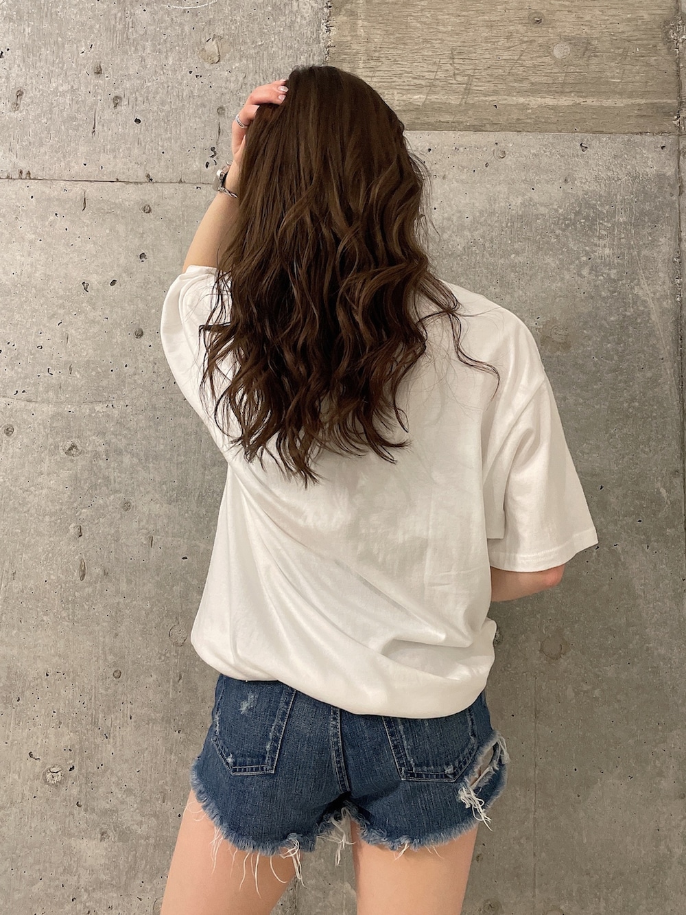 ホワイト系のTシャツ/カットソー、ブルー系のデニムパンツ、ブラック系のサンダルを着用したレディースの春コーディネートの4枚目の写真