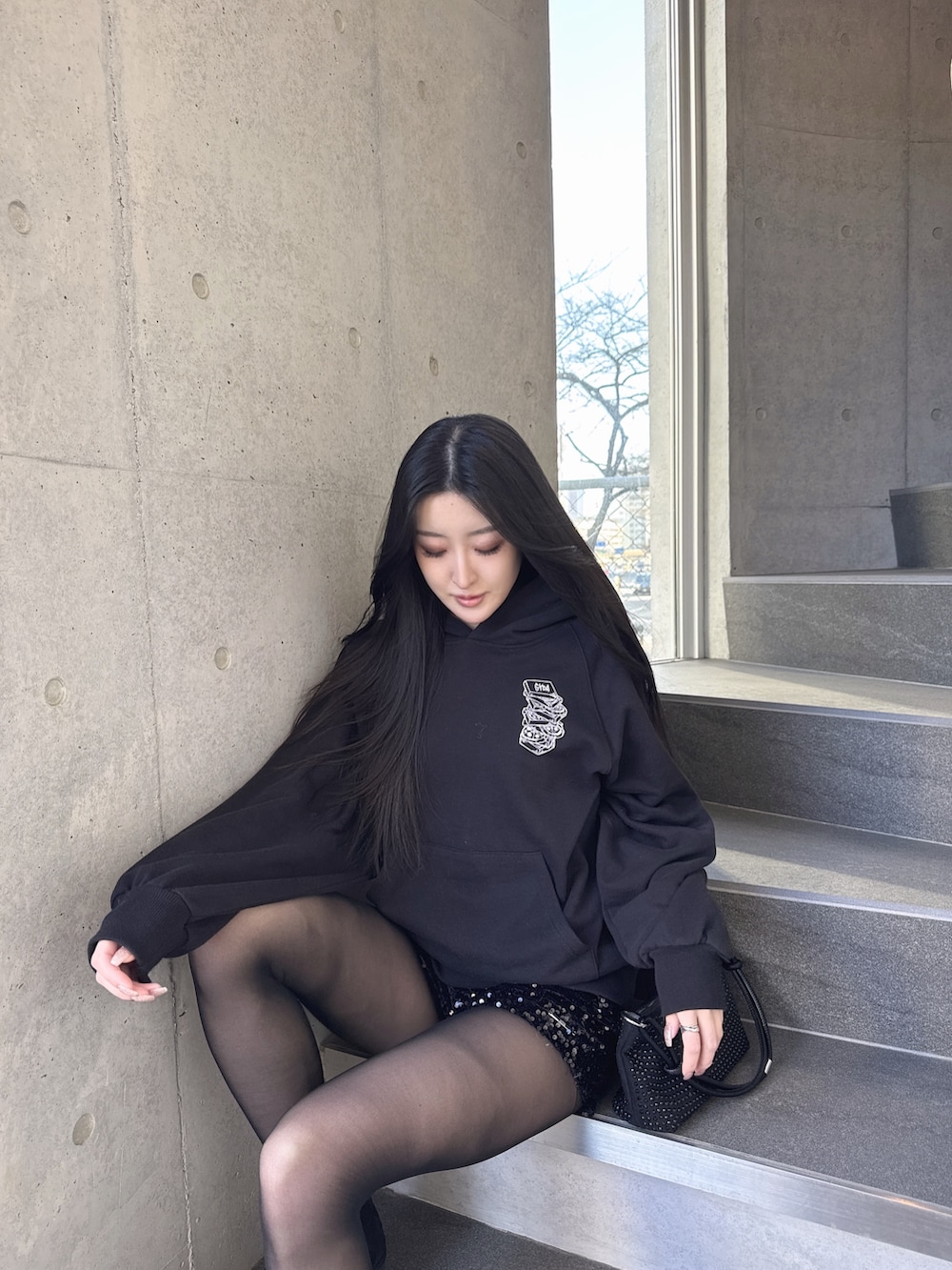 ブラック系のパーカー、ブラック系のその他パンツを着用したレディースの冬コーディネートの3枚目の写真