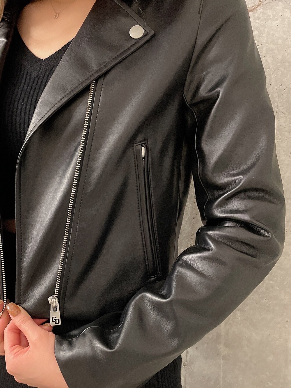 ブラック系のニット/セーター、ブラック系のスカート、ブラック系のライダースジャケットを着用したレディースの冬コーディネートの6枚目の写真