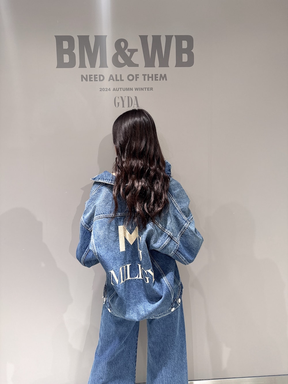 ブルー系のデニムジャケット、ブルー系のデニムパンツ、ホワイト系のパンプスを着用したレディースの秋コーディネートの4枚目の写真