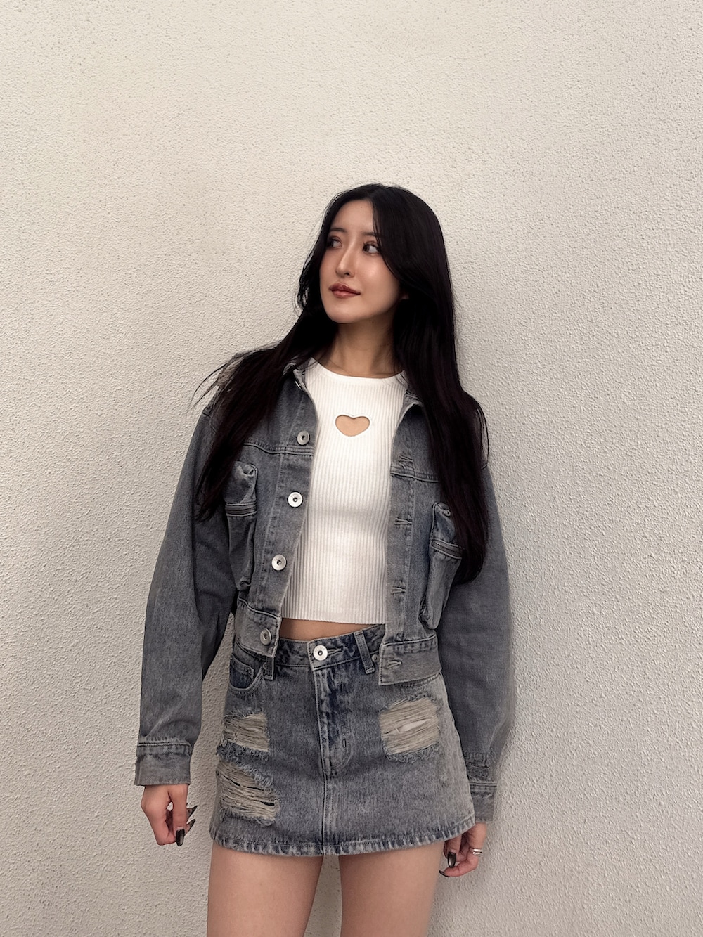 ブルー系のデニムスカート、ブルー系のデニムジャケット、ホワイト系のニット/セーターを着用したレディースの秋コーディネートの2枚目の写真