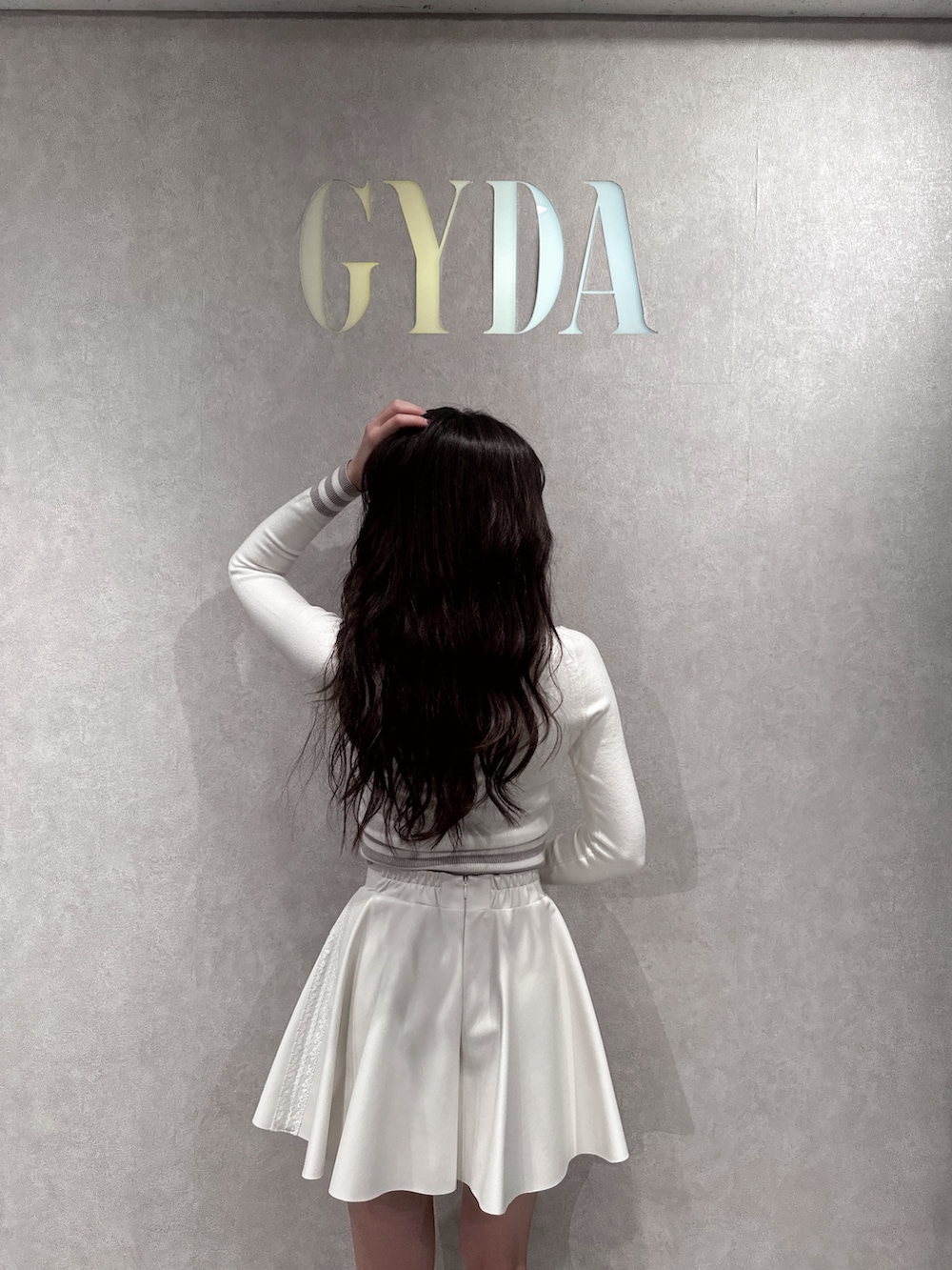 ホワイト系のブルゾン、ホワイト系のニット/セーター、ホワイト系のスカートを着用したレディースの冬コーディネートの5枚目の写真