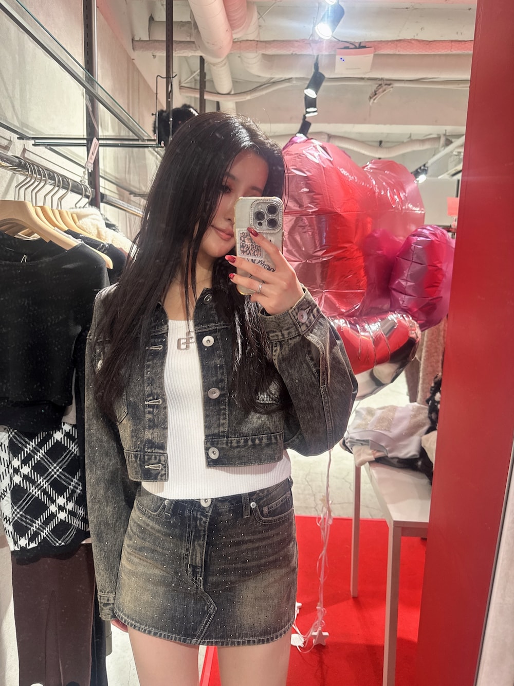 ブラック系のハンドバッグ、ブルー系のデニムジャケット、ブルー系のデニムスカートを着用したレディースの秋コーディネートの6枚目の写真