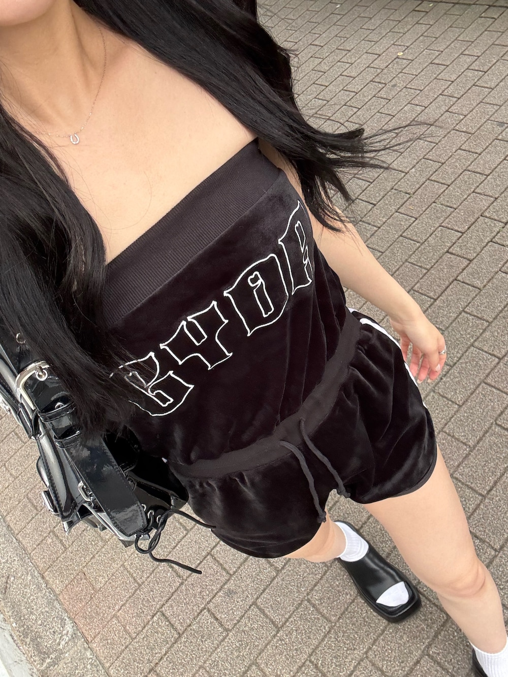 ブラック系のワンピース、ブラック系のハンドバッグ、ブラック系のサンダルを着用したレディースの夏コーディネートの3枚目の写真