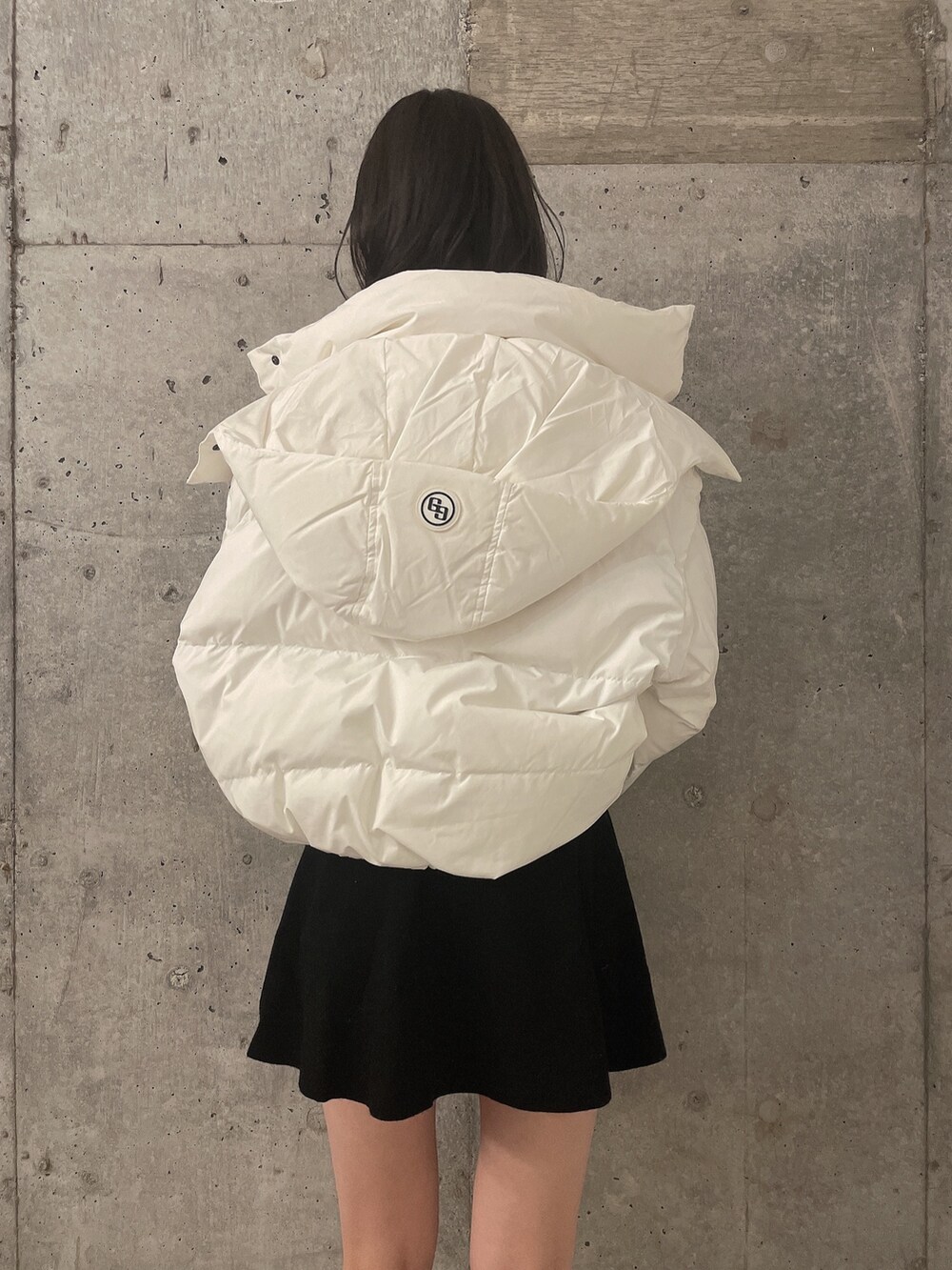 ホワイト系のダウンジャケット/コート、ブラック系のワンピース、ブラック系のブーツを着用したレディースの冬コーディネートの4枚目の写真