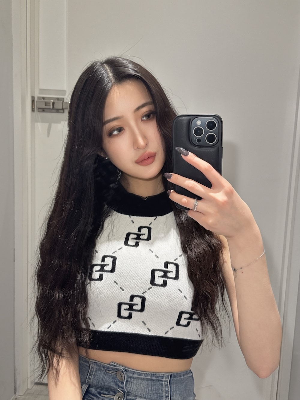 ホワイト系のニット/セーター、ブルー系のデニムパンツ、ホワイト系のサンダルを着用したレディースの春コーディネートの2枚目の写真