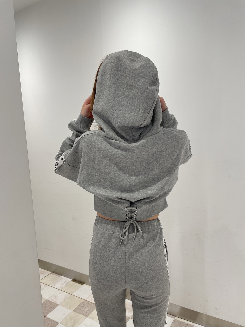 グレー系のパーカー、グレー系のその他パンツ、ホワイト系のパンプスを着用したレディースの冬コーディネートの4枚目の写真