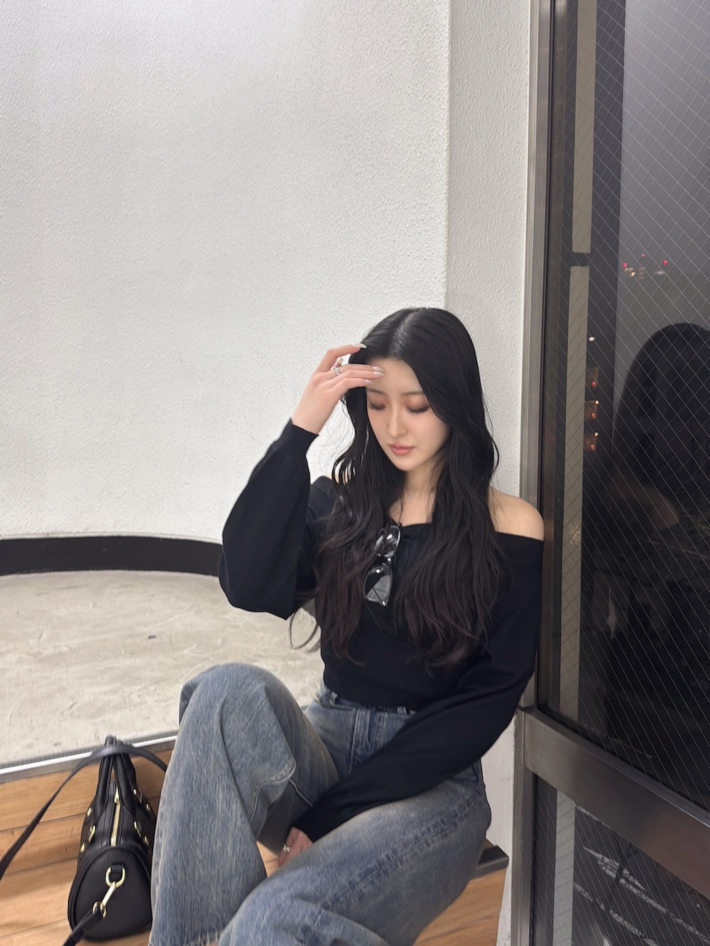 ブラック系のニット/セーター、ブルー系のデニムパンツを着用したレディースの冬コーディネートの4枚目の写真