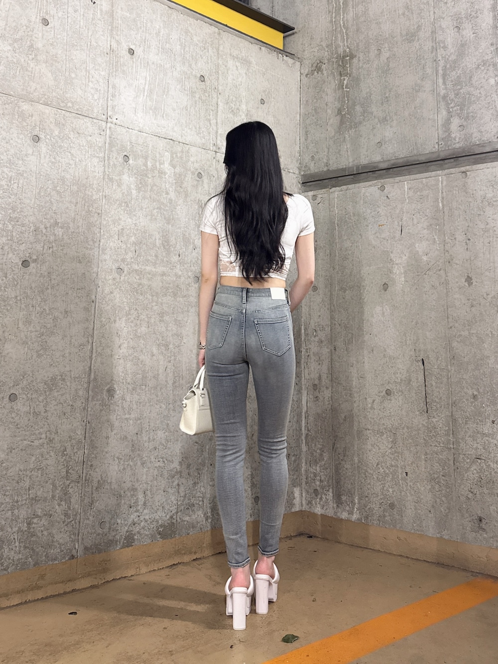 ホワイト系のTシャツ/カットソー、ブルー系のデニムパンツ、ホワイト系のサンダルを着用したレディースの夏コーディネートの3枚目の写真