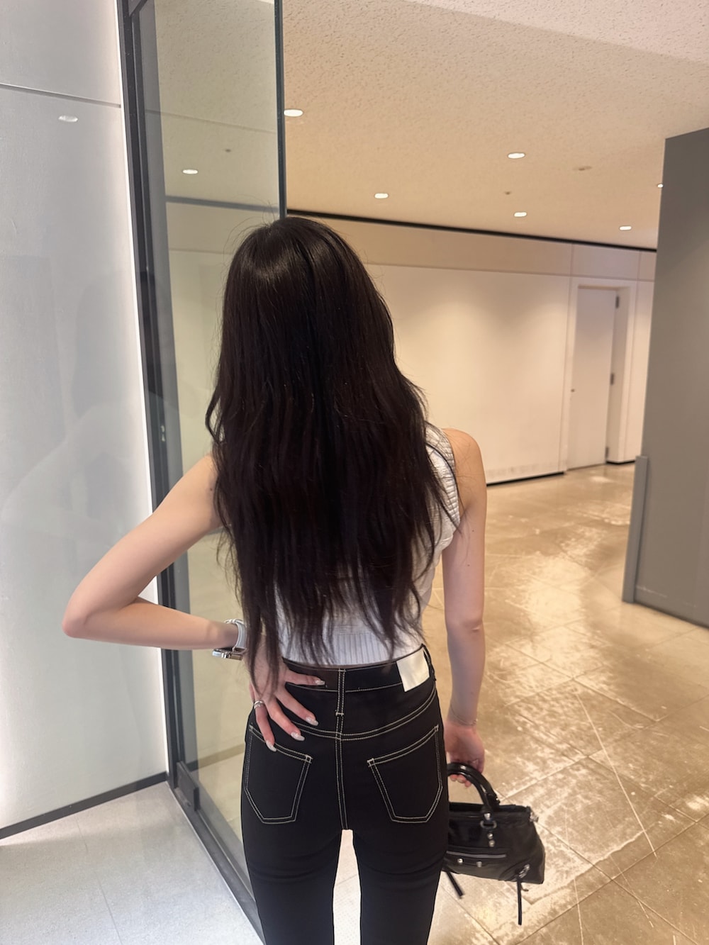 ホワイト系のニット/セーター、ブラック系のデニムパンツ、その他のサンダルを着用したレディースの夏コーディネートの3枚目の写真