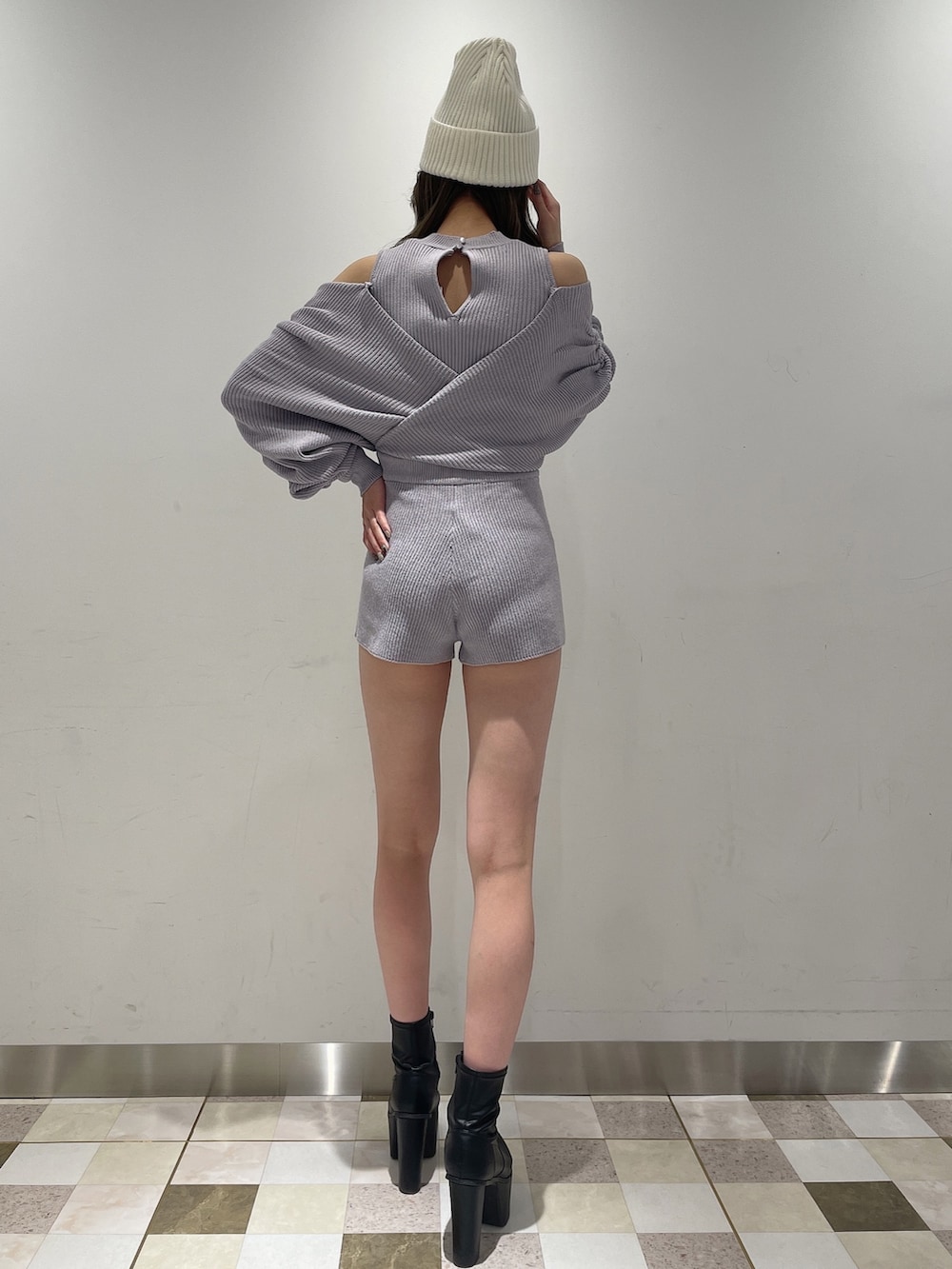 パープル系のサロペット/オーバーオール、ブラック系のブーツ、ホワイト系のニットキャップ/ビーニーを着用したレディースの冬コーディネートの6枚目の写真