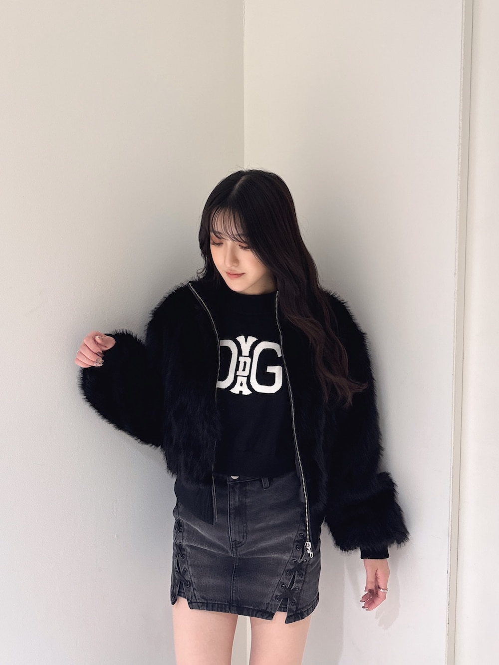 ブラック系のその他アウター、ブラック系のニット/セーター、ブラック系のデニムスカートを着用したレディースの秋コーディネートの3枚目の写真