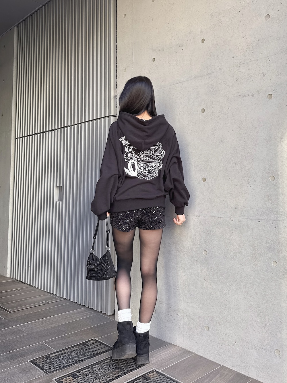 ブラック系のパーカー、ブラック系のその他パンツを着用したレディースの冬コーディネートの2枚目の写真