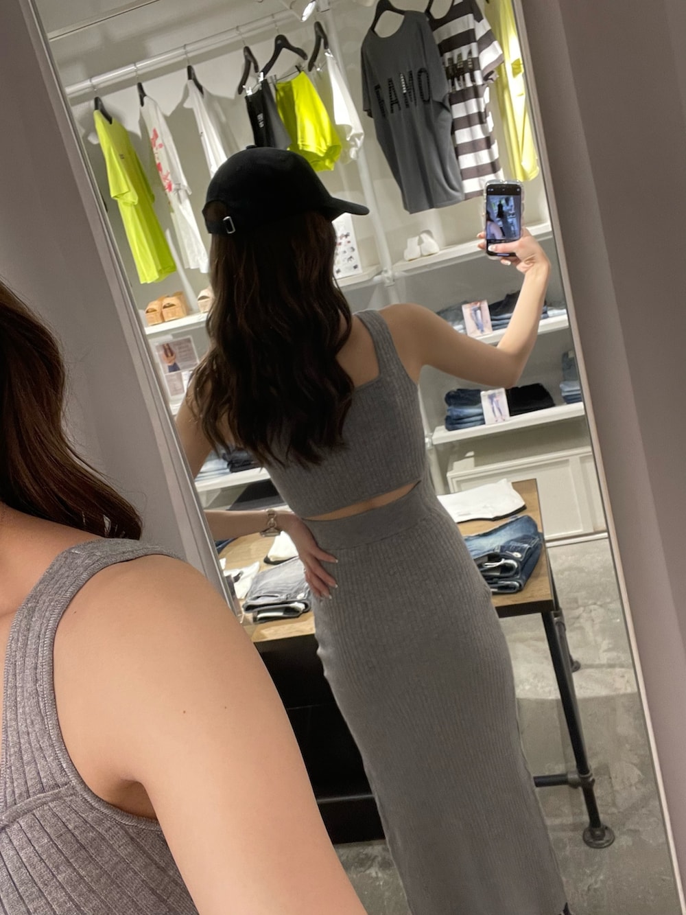 ホワイト系のパーカー、ベージュ系のワンピース、ブラック系のサンダルを着用したレディースの春コーディネートの3枚目の写真