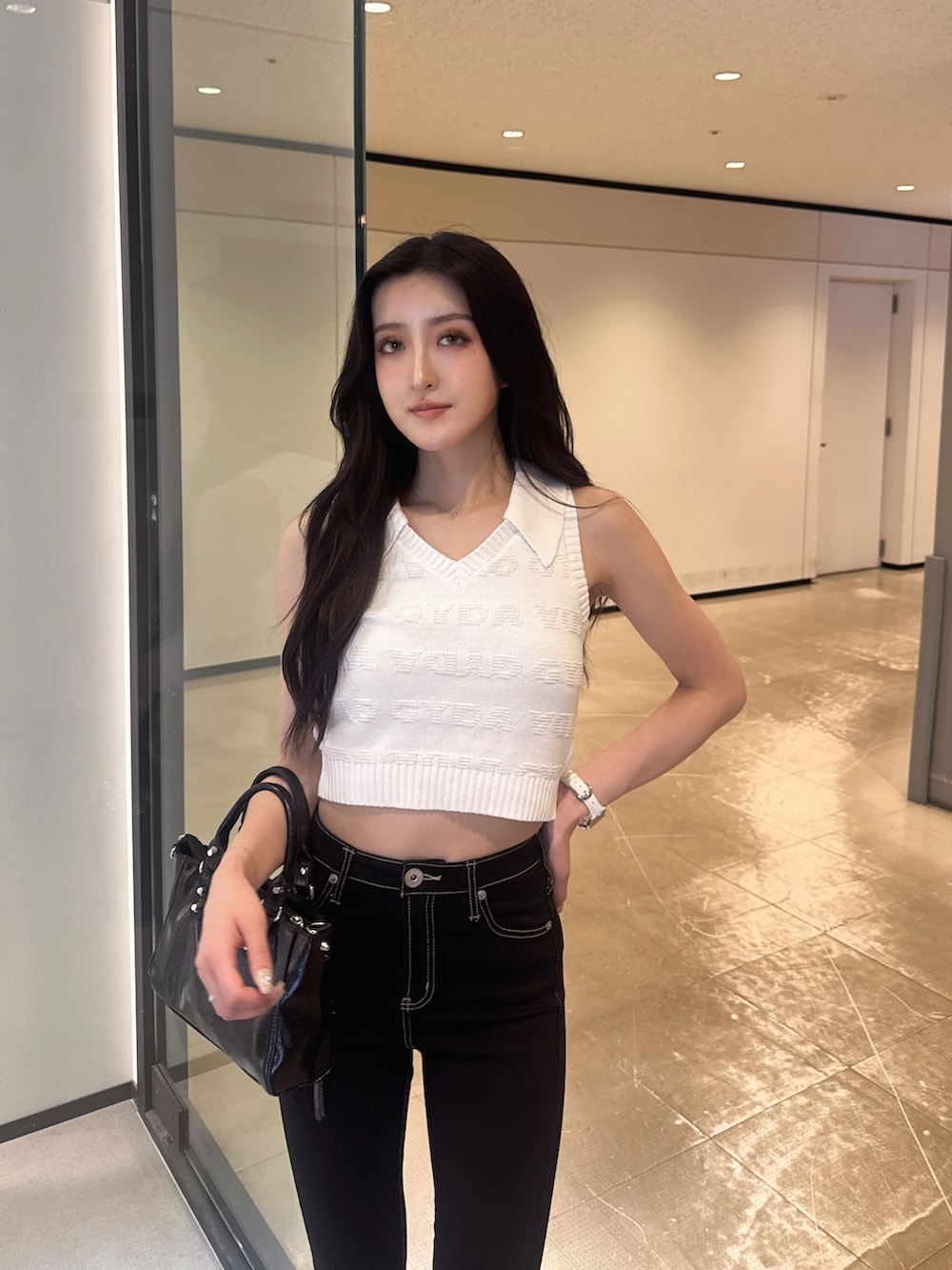 ホワイト系のニット/セーター、ブラック系のデニムパンツ、その他のサンダルを着用したレディースの夏コーディネートの2枚目の写真