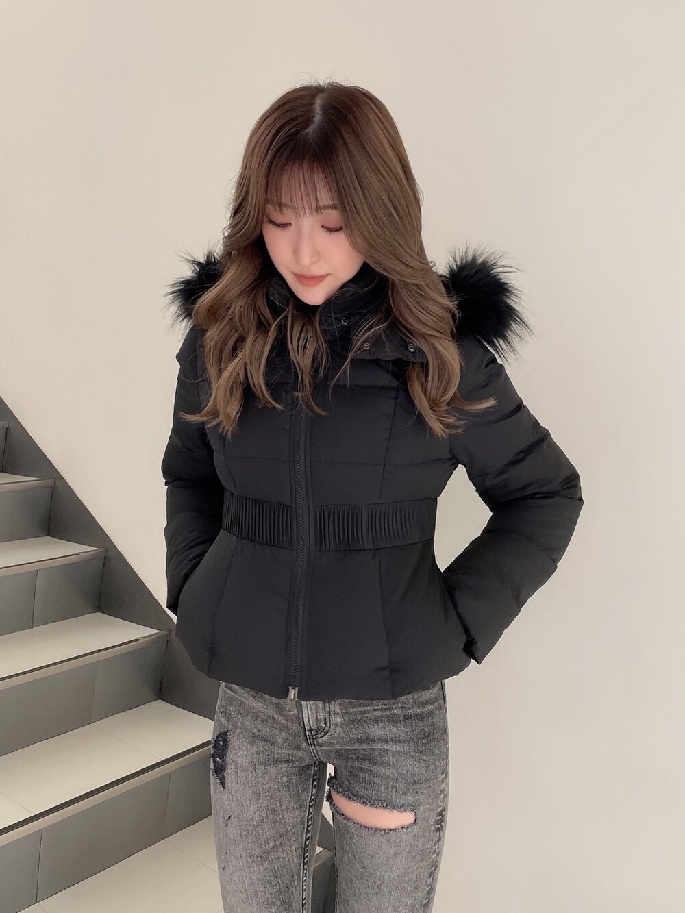 ブラック系のデニムパンツ、ホワイト系のパンプス、ブラック系のその他アウターを着用したレディースの冬コーディネートの3枚目の写真