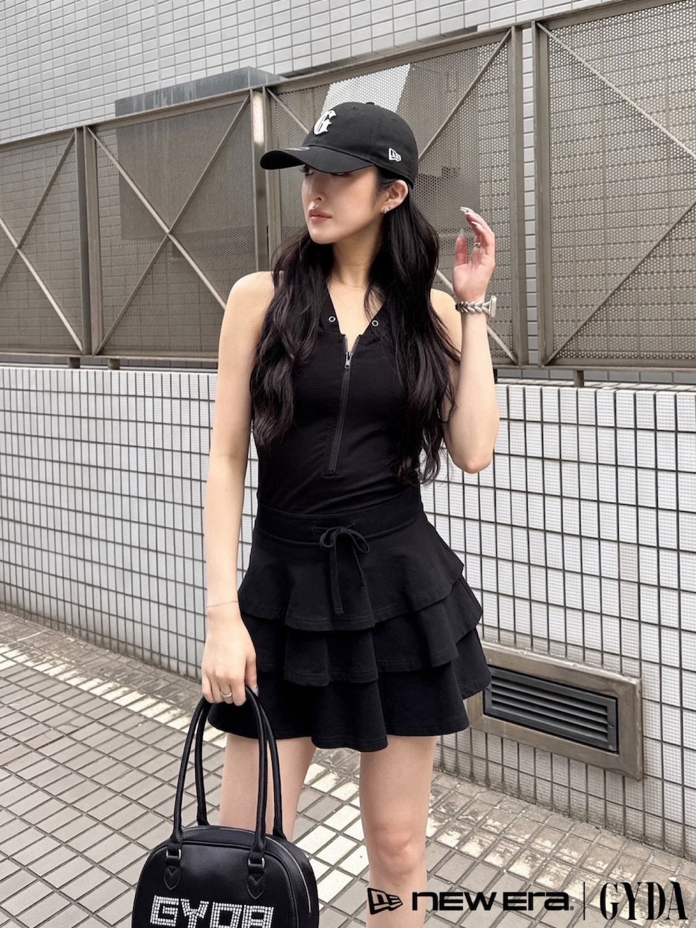 ブラック系のワンピース、ブラック系のボストンバッグ、ブラック系のキャップを着用したレディースの夏コーディネートの4枚目の写真