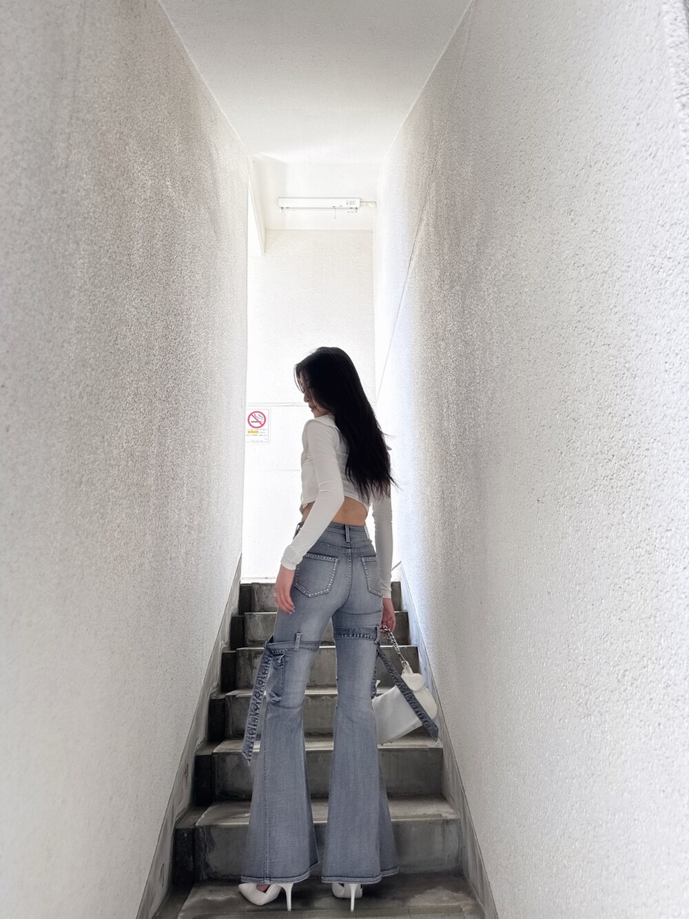 ホワイト系のTシャツ/カットソー、ブルー系のデニムパンツ、ホワイト系のパンプスを着用したレディースの夏コーディネートの4枚目の写真