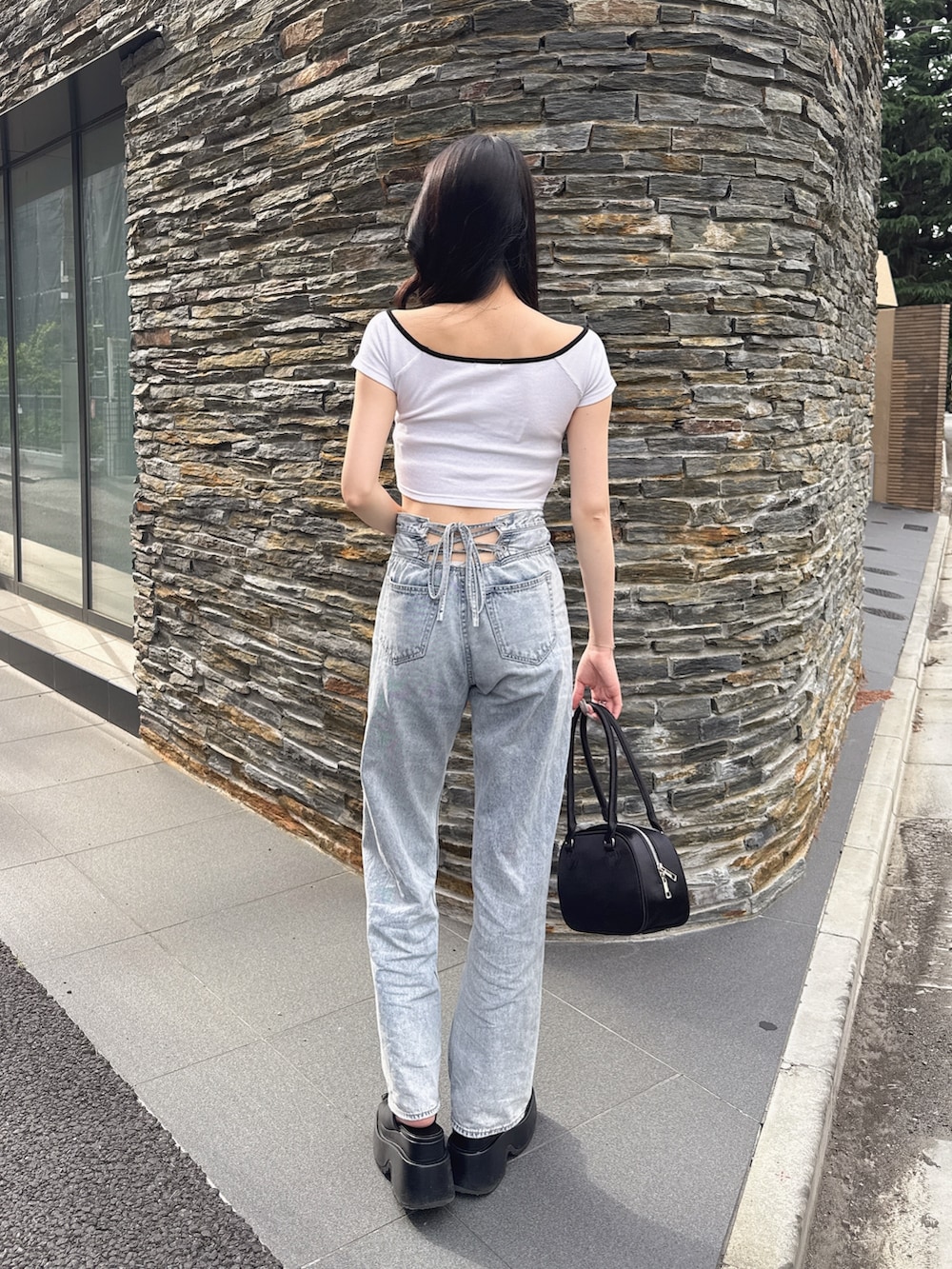 ホワイト系のTシャツ/カットソー、ブラック系のボストンバッグ、ブルー系のデニムパンツを着用したレディースの夏コーディネートの3枚目の写真